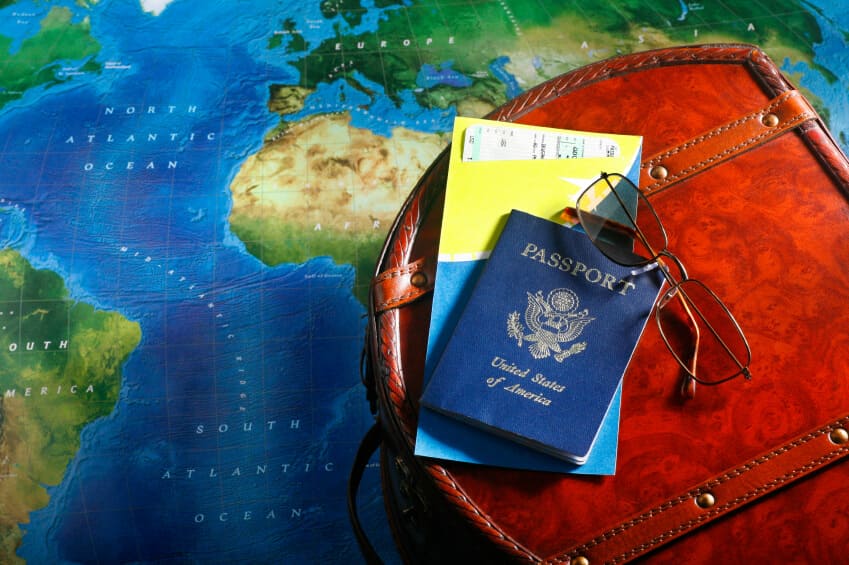 Documentos para visto americano: imagem mostra mapa-múndi de fundo com passaporte.