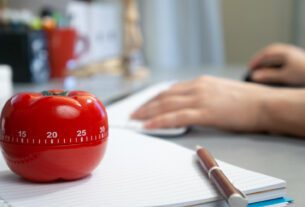 cronômetro em formato de tomate em cima da mesa marcando o método pomodoro