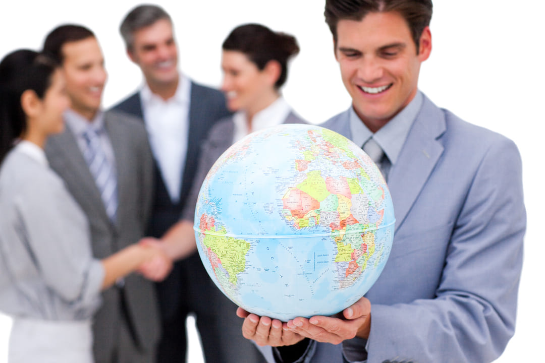 Homem segurando um globo terrestre e outros executivos atrás, representando os benefícios de uma especialização internacional.